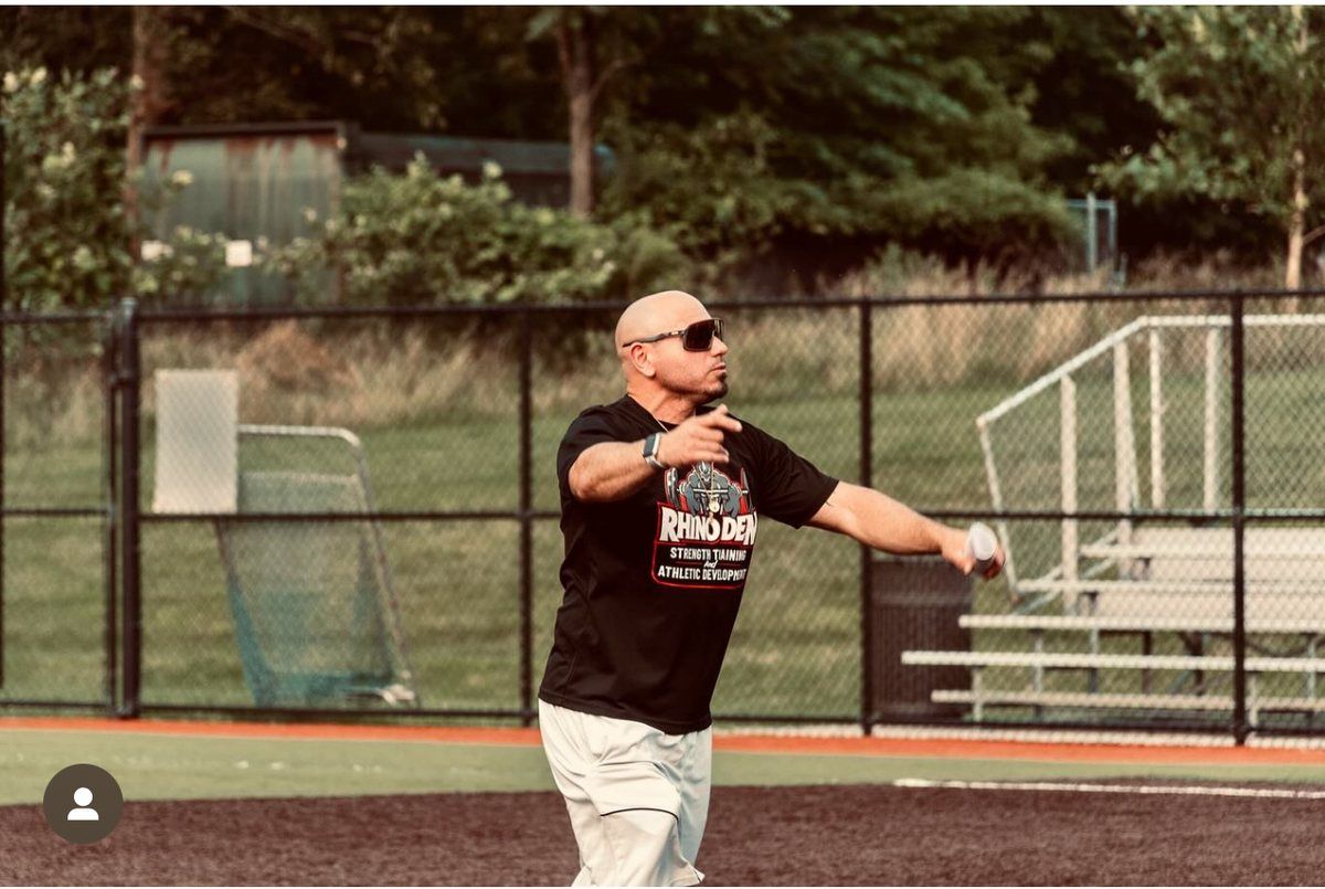 Coach Rob coaching outdoors on the field in Rhino Den gear
